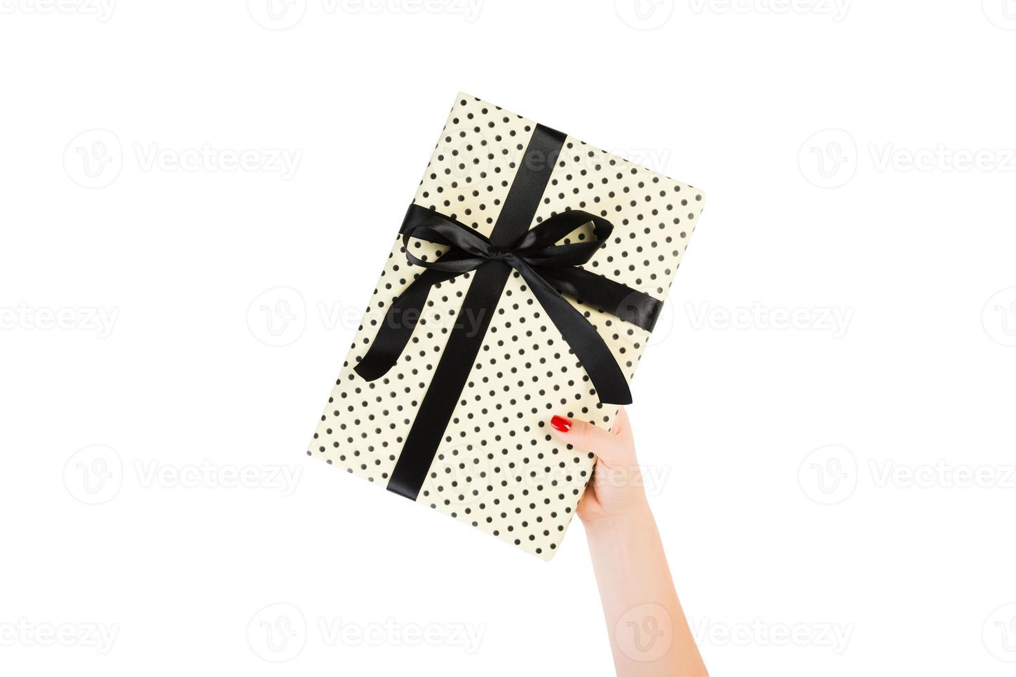 vrouw handen geven verpakt Kerstmis of andere vakantie handgemaakt Cadeau in geel papier met zwart lintje. geïsoleerd Aan wit achtergrond, top visie. dankzegging geschenk doos concept foto