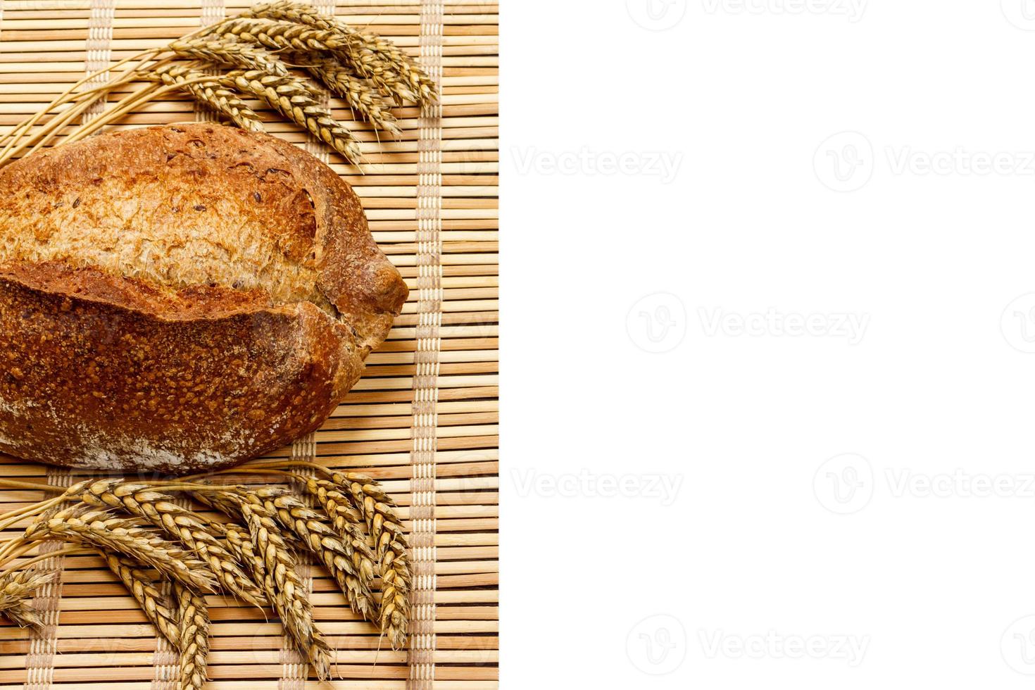 lekker biologisch brood van brood met tarwe Aan houten plank geïsoleerd Aan wit foto