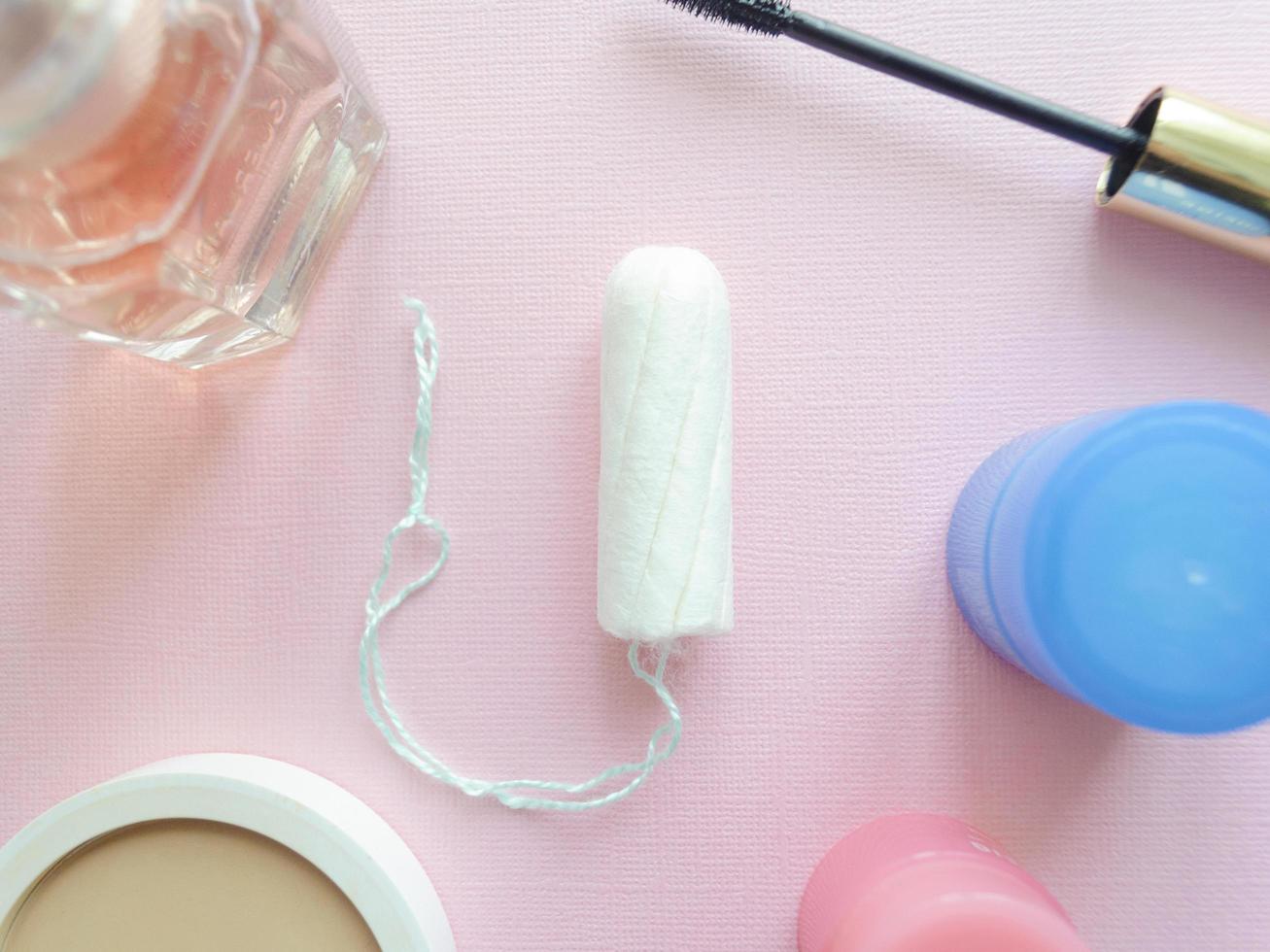 medisch vrouw tampon Aan een roze achtergrond. hygiënisch wit tampon voor Dames. katoen wattenstaafje. menstruatie, bescherming concept. vlak leggen. foto