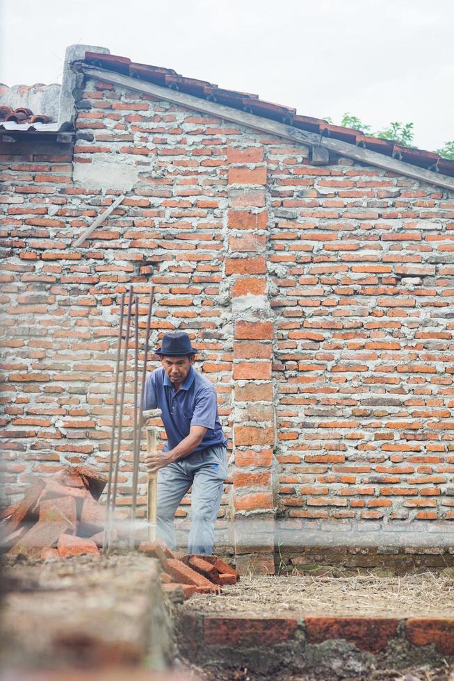 tegal, jawa tenga, 2022 - bouw arbeider nemen metingen met wit draad voor buitenkant muur bouw foto