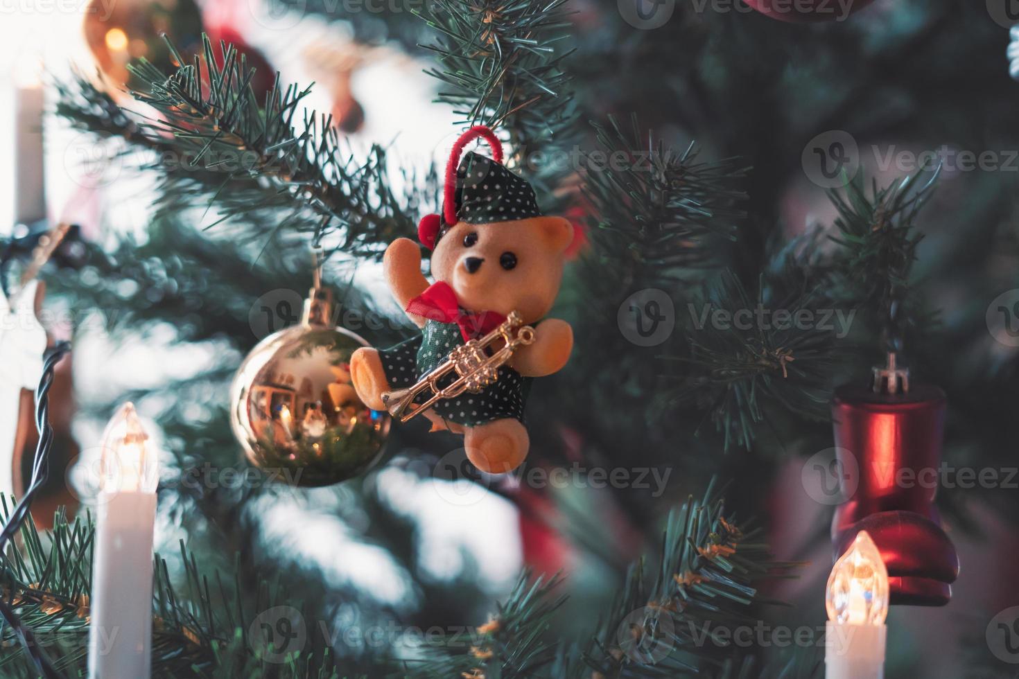 Kerstmis boom decoratie. detailopname van beer en snuisterij hangende van een versierd Kerstmis boom foto