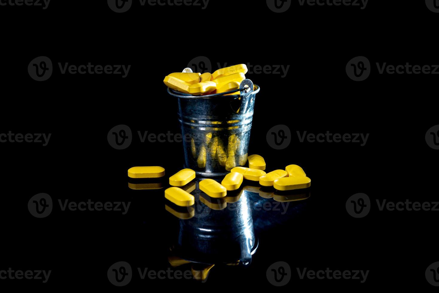 wit oranje pillen in wijnglas glas . in kan. in emmer geïsoleerd Aan zwart reeks van capsule en pillen binnen detailopname, foto