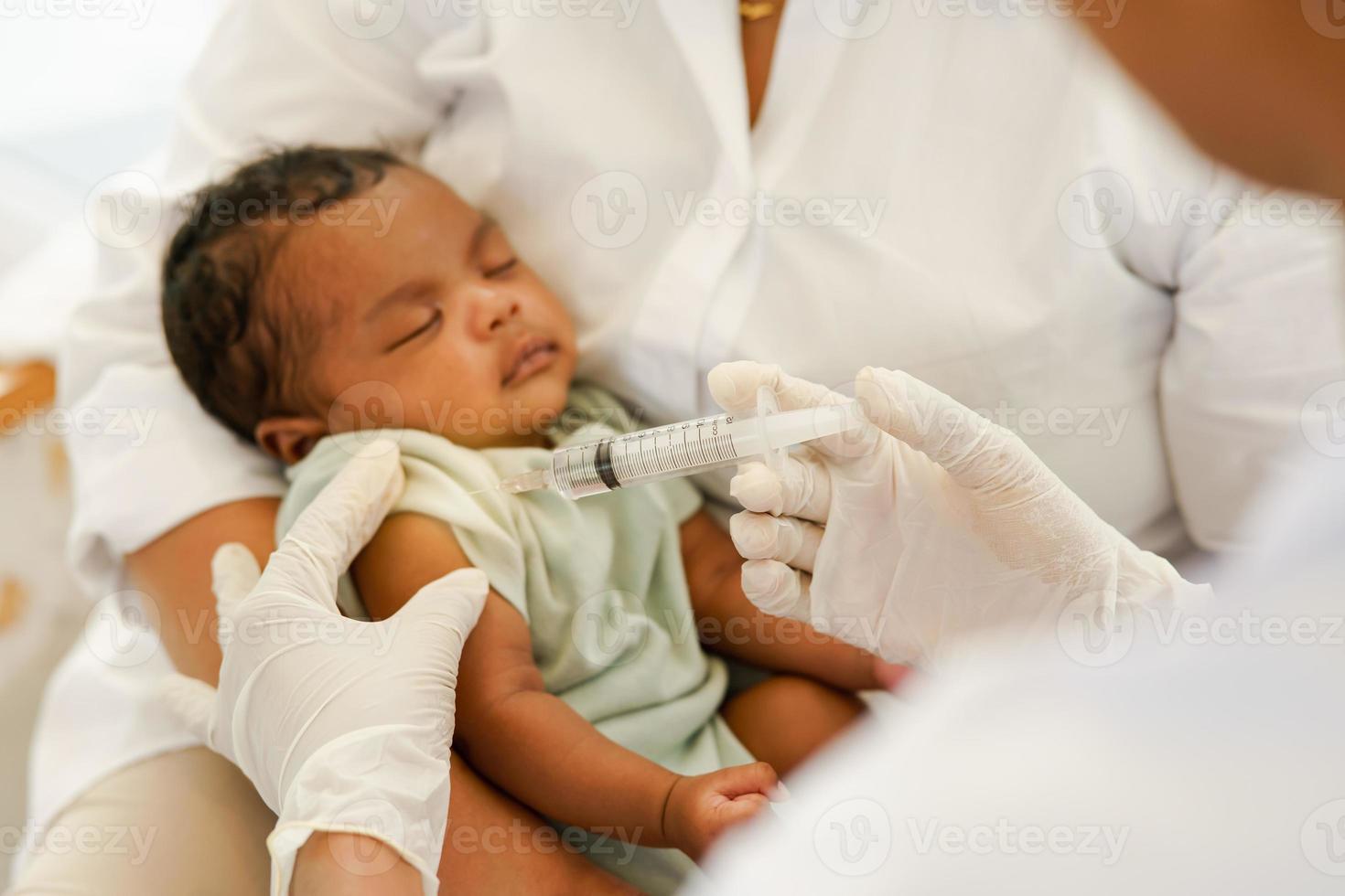 dichtbij omhoog van de hand- en naald. dokter houdt injectiespuit naar vaccineren pasgeboren baby een maand oud met injectie. concept kliniek kinderarts Gezondheid controleren vaccin antivirus voor zuigeling. foto