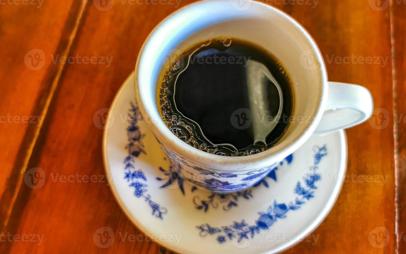 blauw wit kop pot met zwart koffie houten tafel Mexico. foto