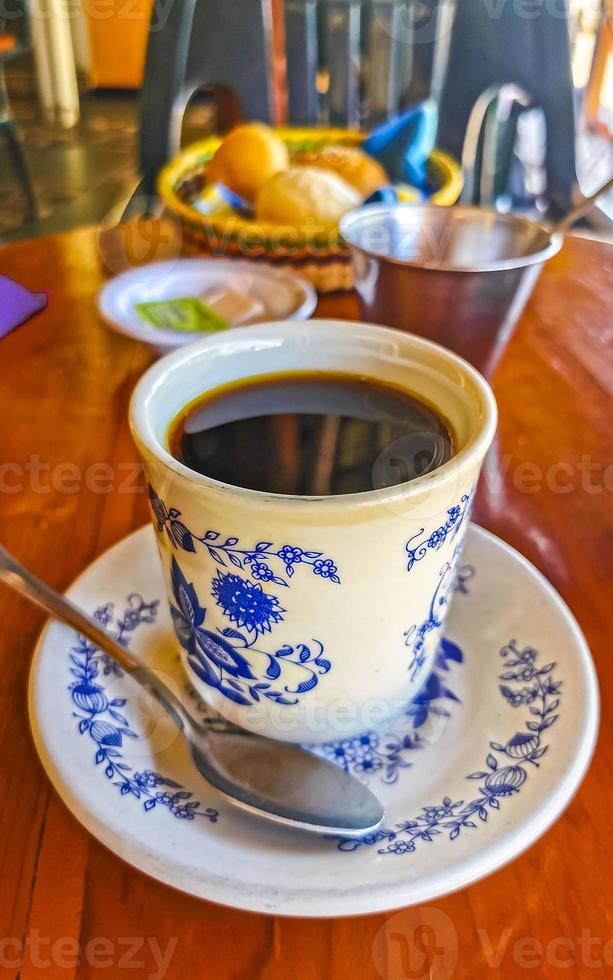 blauw wit kop pot met zwart koffie houten tafel Mexico. foto