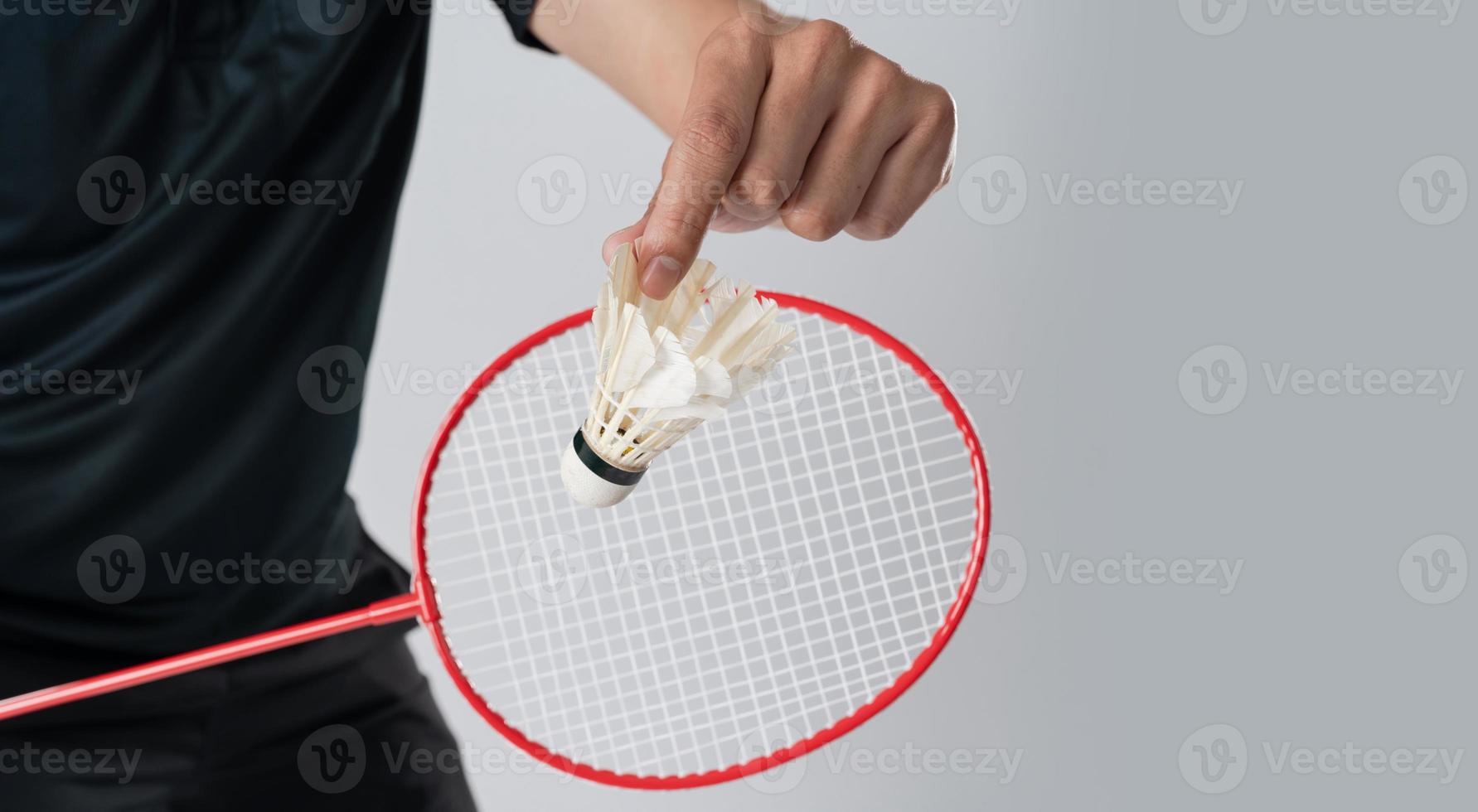 een badminton speler in sportkleding staat Holding een racket en shuttle foto