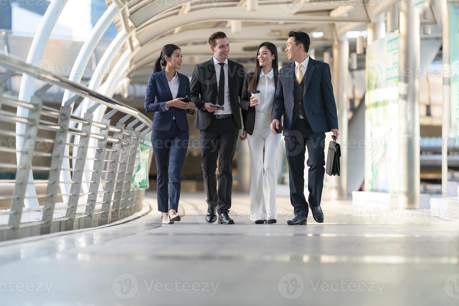 bedrijf mensen wandelen en praten naar elk andere in voorkant van modern kantoor foto