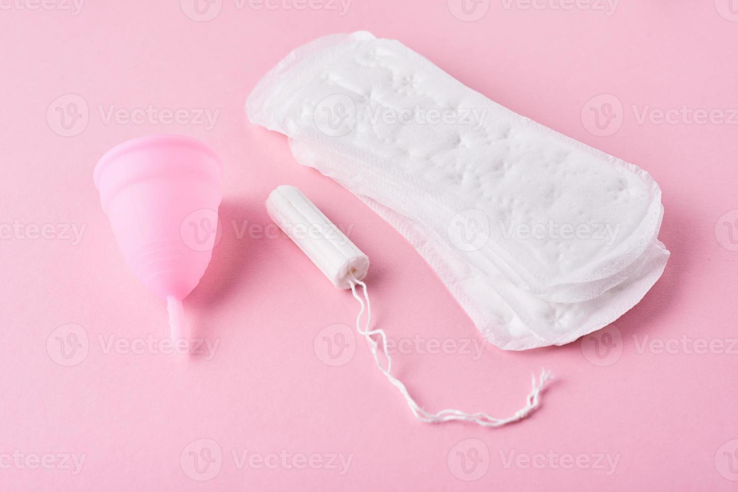 sanitair kussen, menstruatie- kop en tampon Aan een roze achtergrond foto