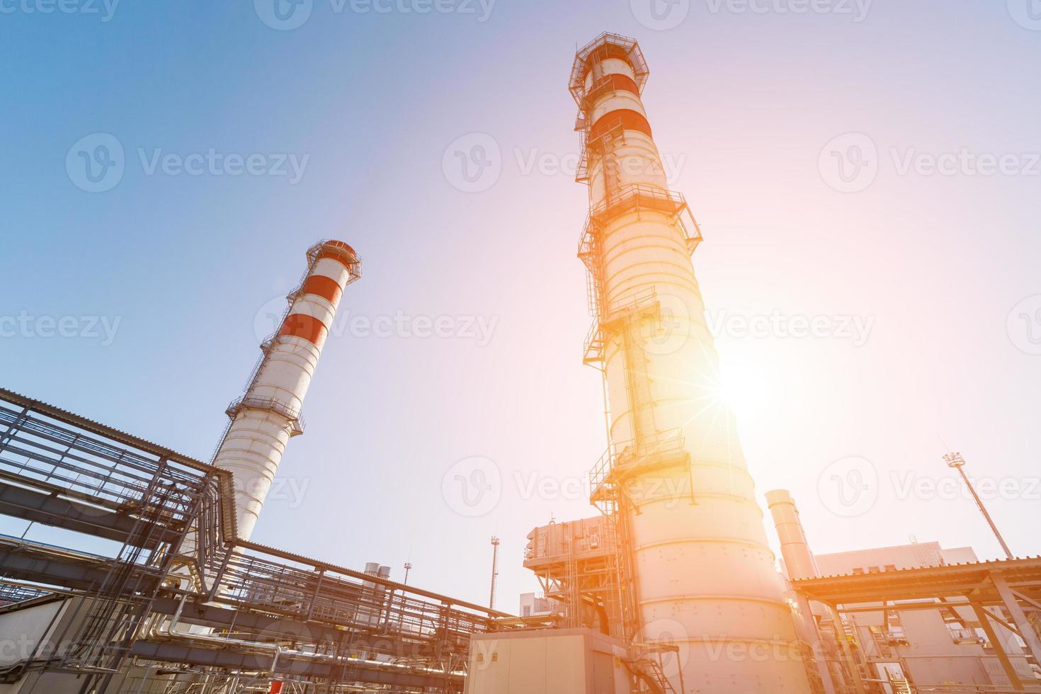 gas- turbine macht fabriek Aan natuurlijk gas- met schoorstenen van rood Wit kleur tegen een blauw lucht Aan een zonnig dag foto