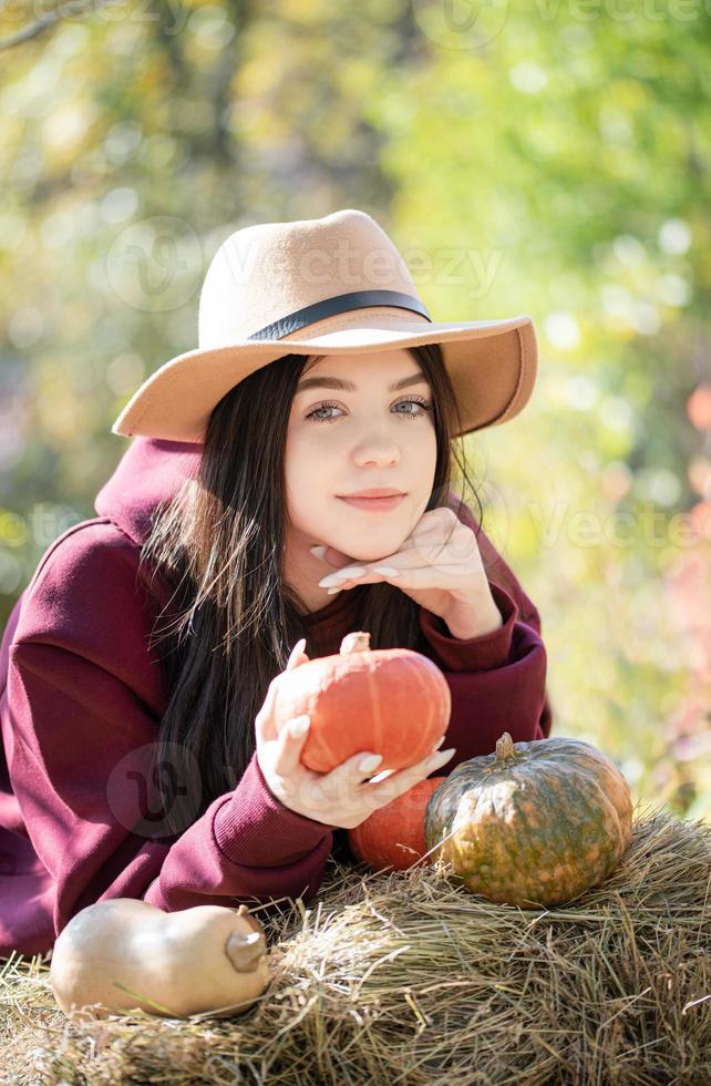 gelukkig jong meisje met pompoen in herfst tuin foto