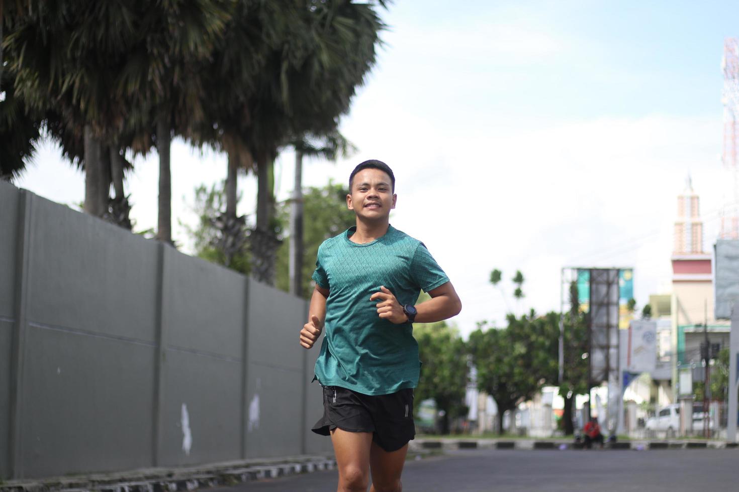 jong Aziatisch jongen opwarming omhoog voor jogging in de ochtend- foto