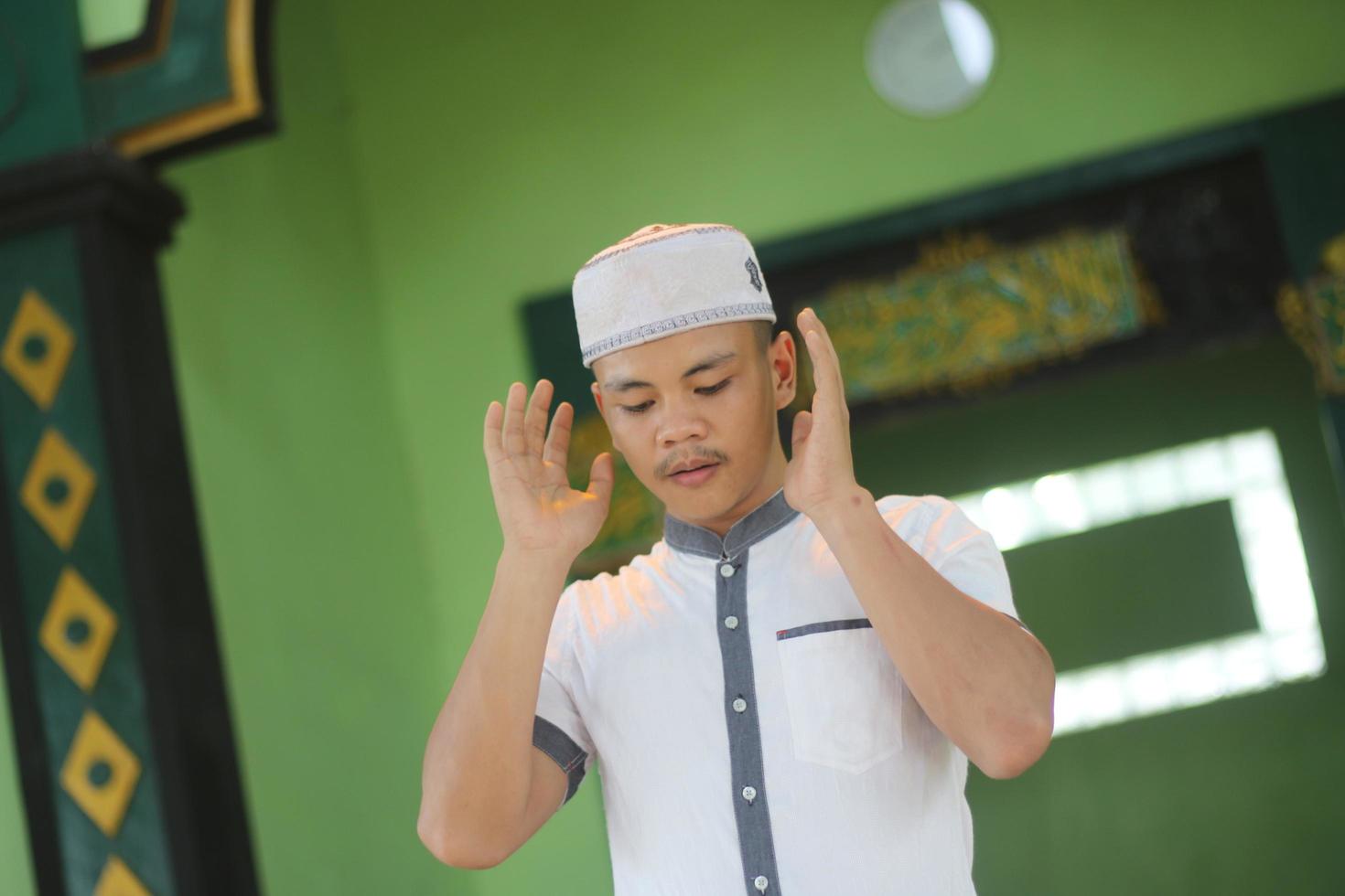 jong Aziatisch moslim bidden in de moskee foto