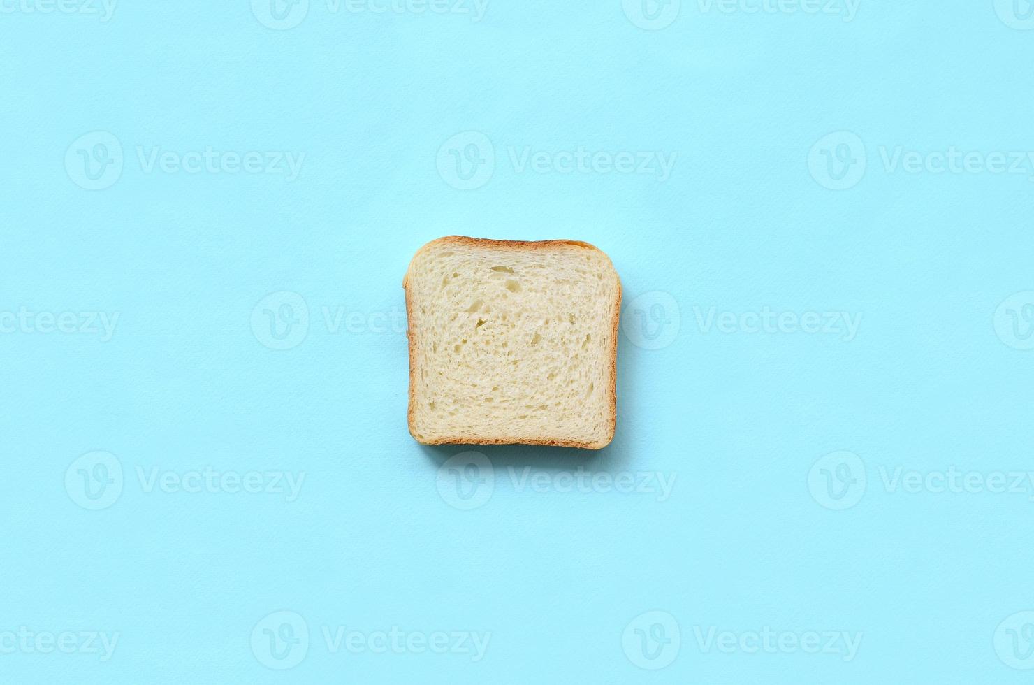 een stuk van brood leugens Aan structuur achtergrond van mode pastel blauw kleur papier in minimaal concept foto