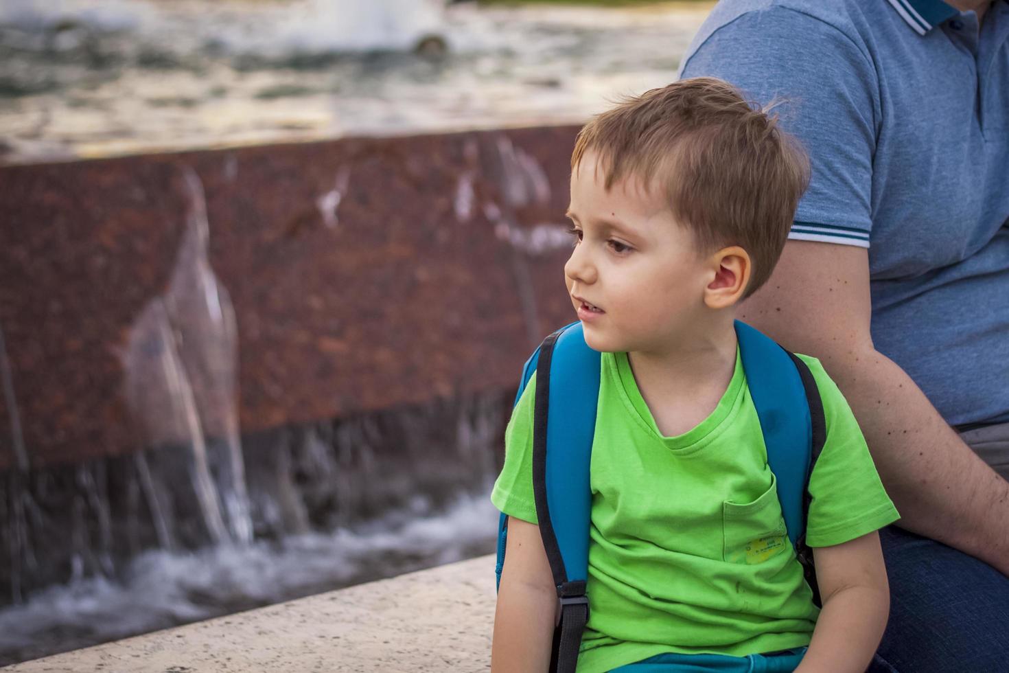 portret van een kind, een jongen tegen de backdrop van stedelijk landschappen van wolkenkrabbers en hoogbouw gebouwen in de Open lucht. kinderen, reizen. levensstijl in de stad. centrum, straten. foto