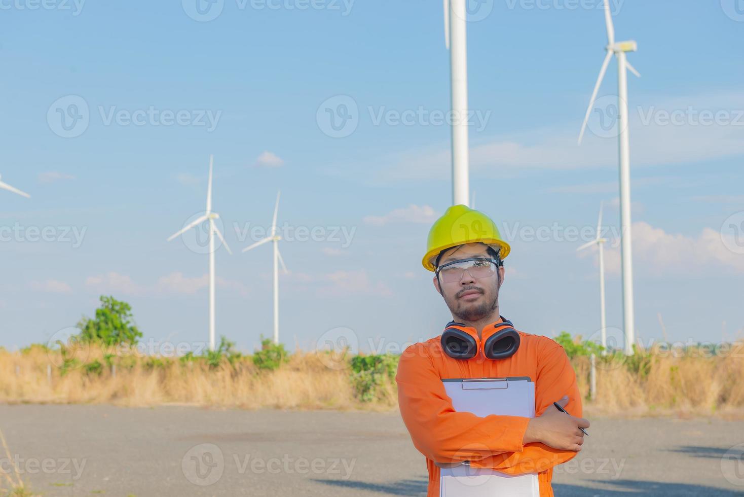 silhouet van Mens ingenieur werken en Holding de verslag doen van Bij wind turbine boerderij macht generator station Aan berg, thailand mensen foto