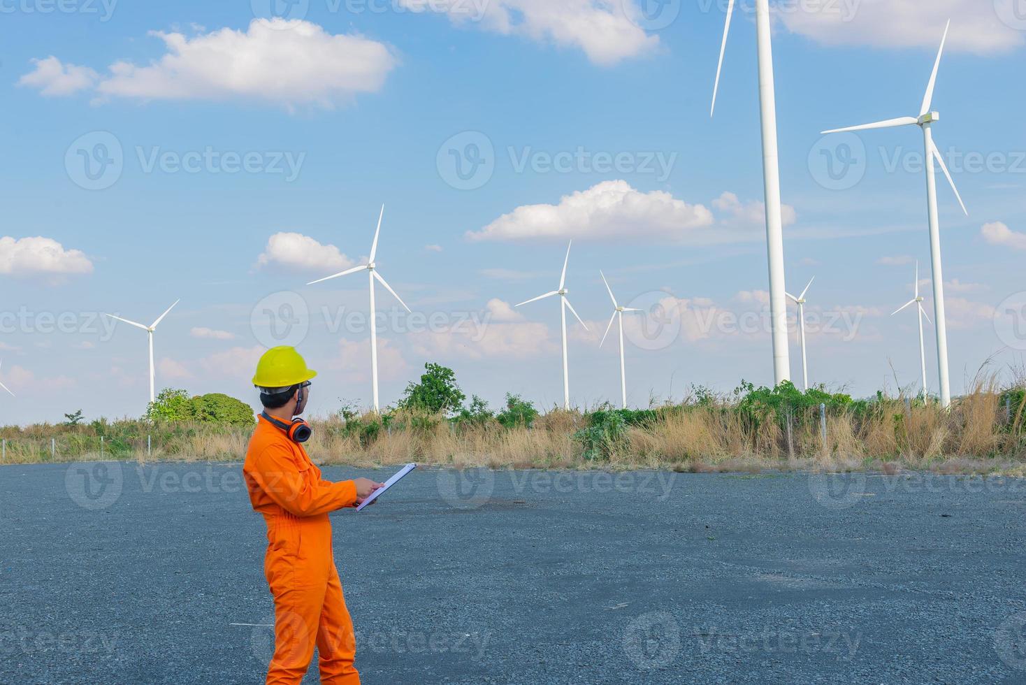 silhouet van Mens ingenieur werken en Holding de verslag doen van Bij wind turbine boerderij macht generator station Aan berg, thailand mensen foto
