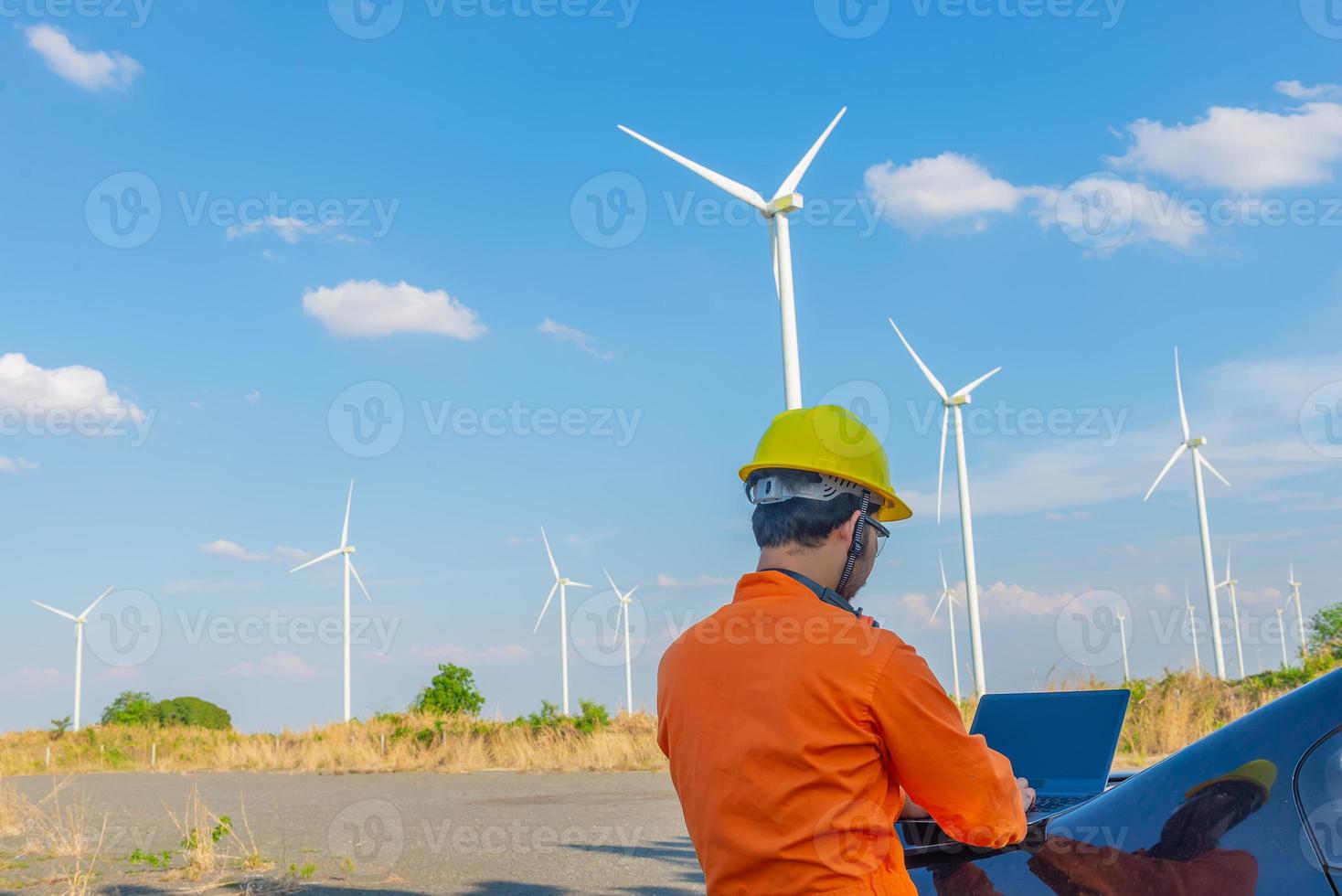 silhouet van Mens ingenieur werken en Holding de verslag doen van Bij wind turbine boerderij macht generator station Aan berg, thailand mensen foto