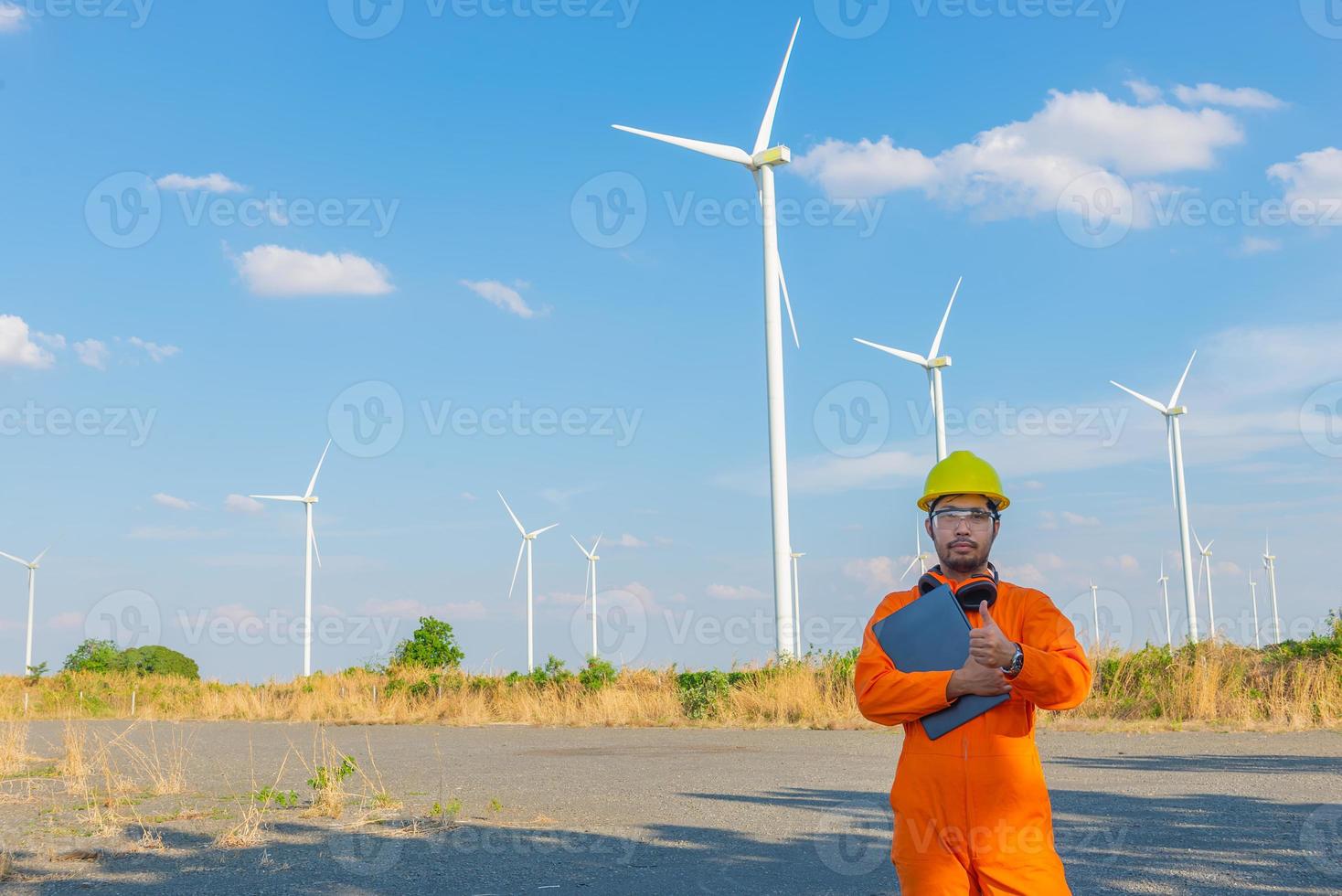 silhouet van Mens ingenieur werken en Holding de verslag doen van Bij wind turbine boerderij macht generator station Aan berg, thailand mensen foto