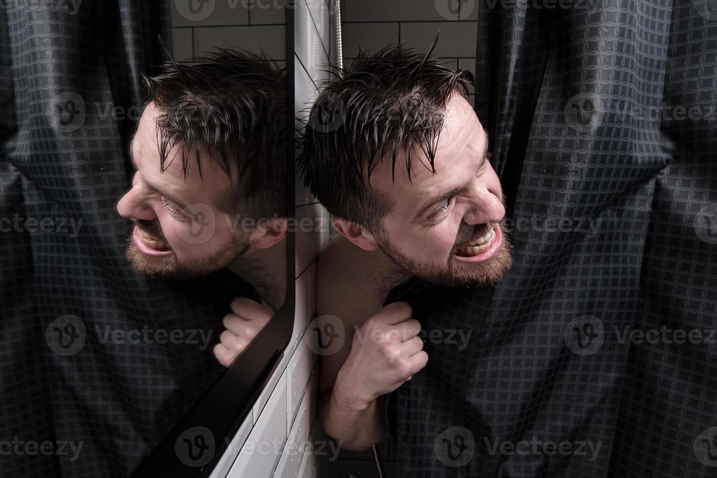 nat Mens looks uit van achter een douche gordijn, looks kwaadaardig Bij iemand en Bares zijn tanden. foto