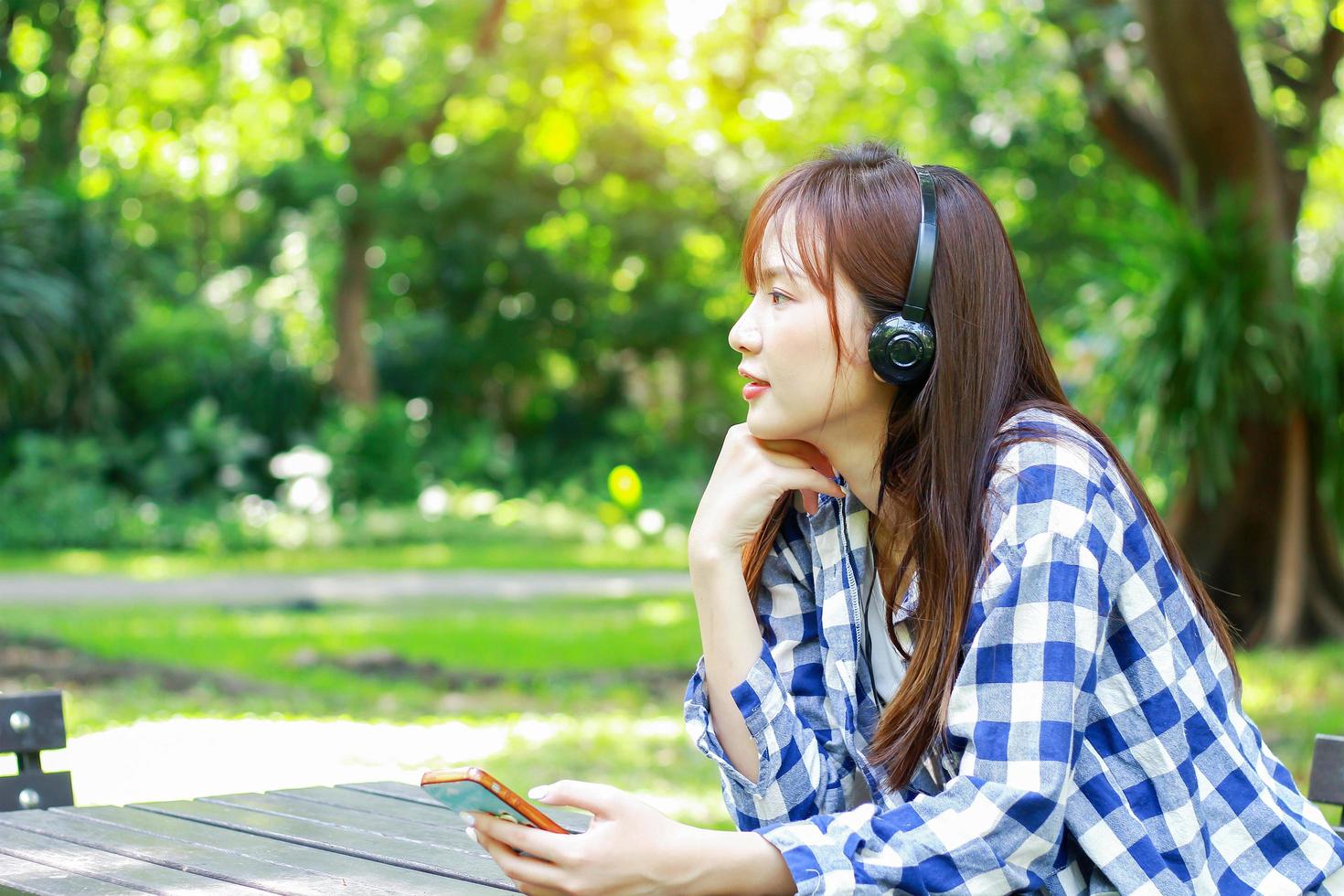 vrouw luisteren naar muziek in het park foto