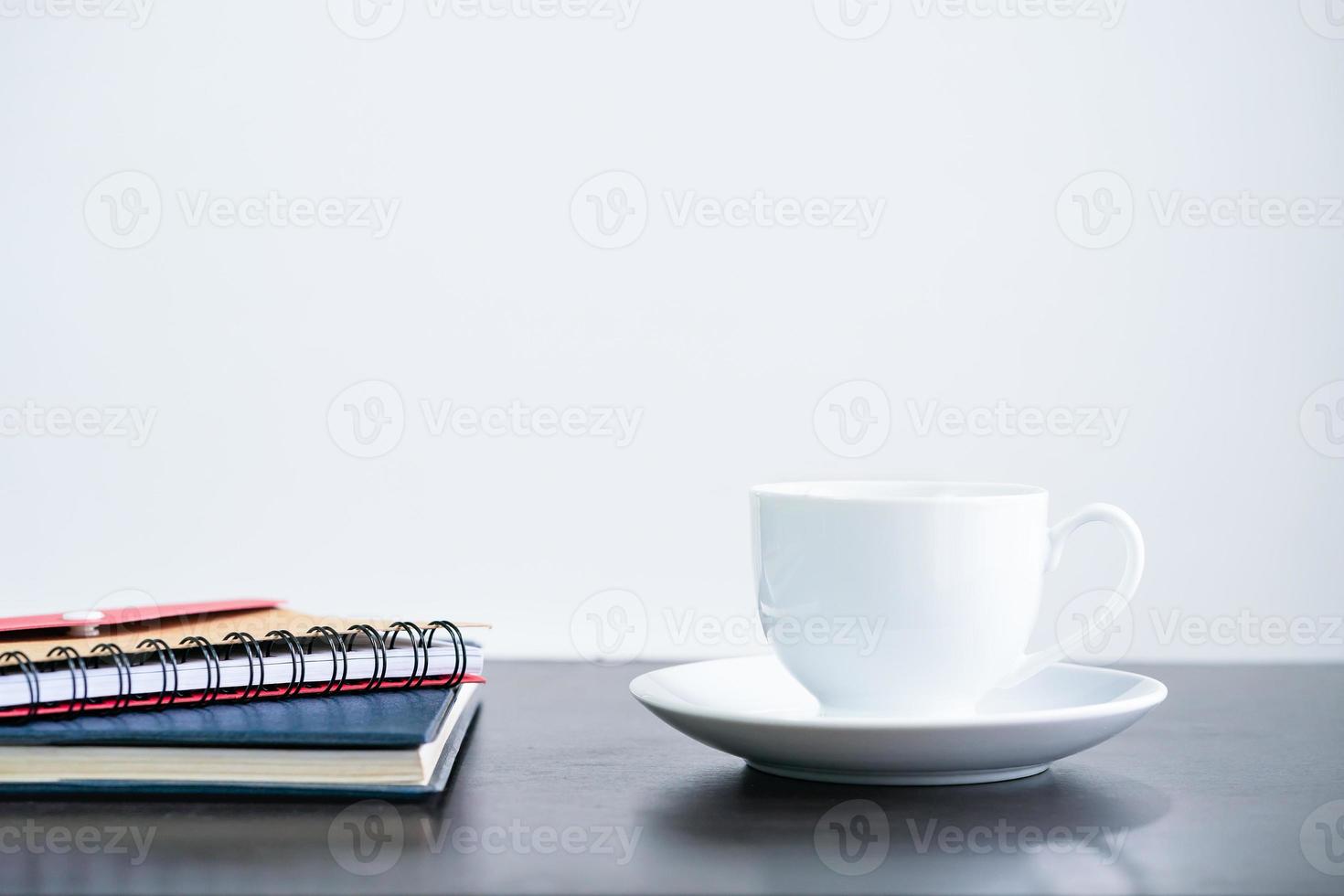 koffie kop en notitieboekje Aan bureau foto