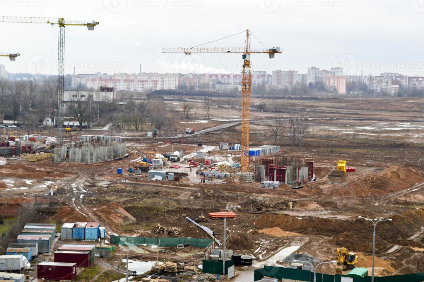 top visie van de bouw plaats gedurende de bouw van een nieuw behuizing landgoed met hoog huizen, nieuw gebouwen met de helpen van groot industrieel kranen en professioneel uitrusting in een groot stad foto