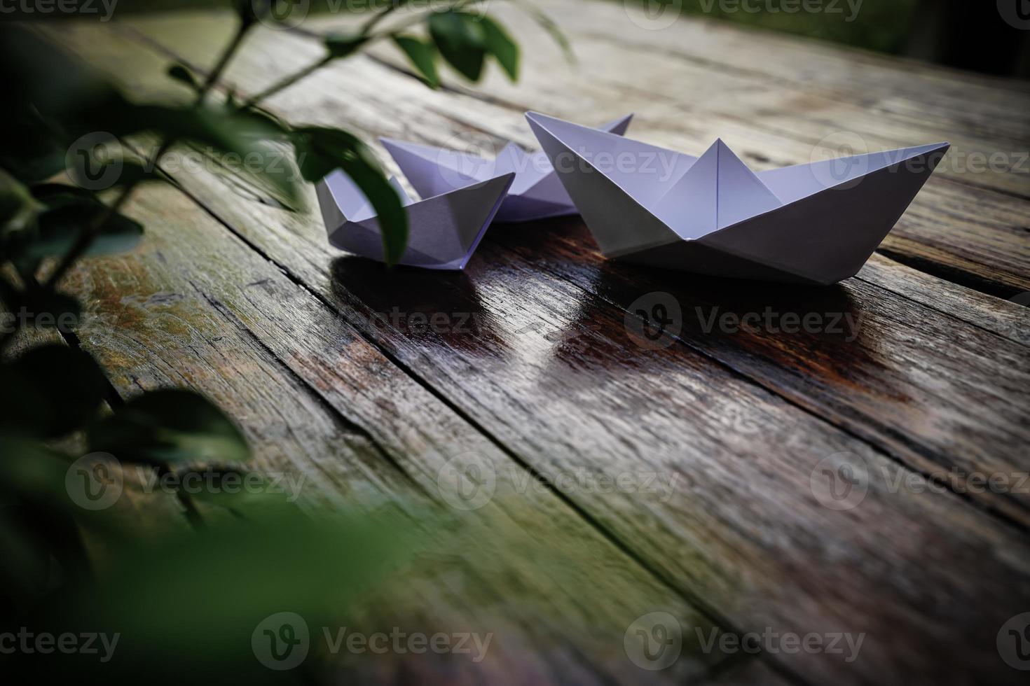 origami, wit papier boot geïsoleerd Aan een houten vloer. papier boten gemeen wandelen. gevoel van vrijheid leiderschap foto