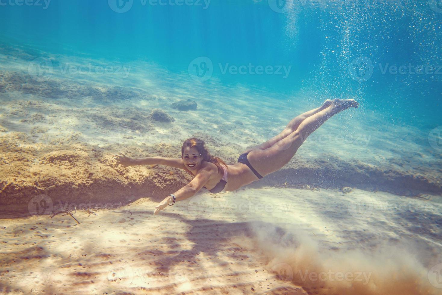 meisje zwemmen onder de zee foto