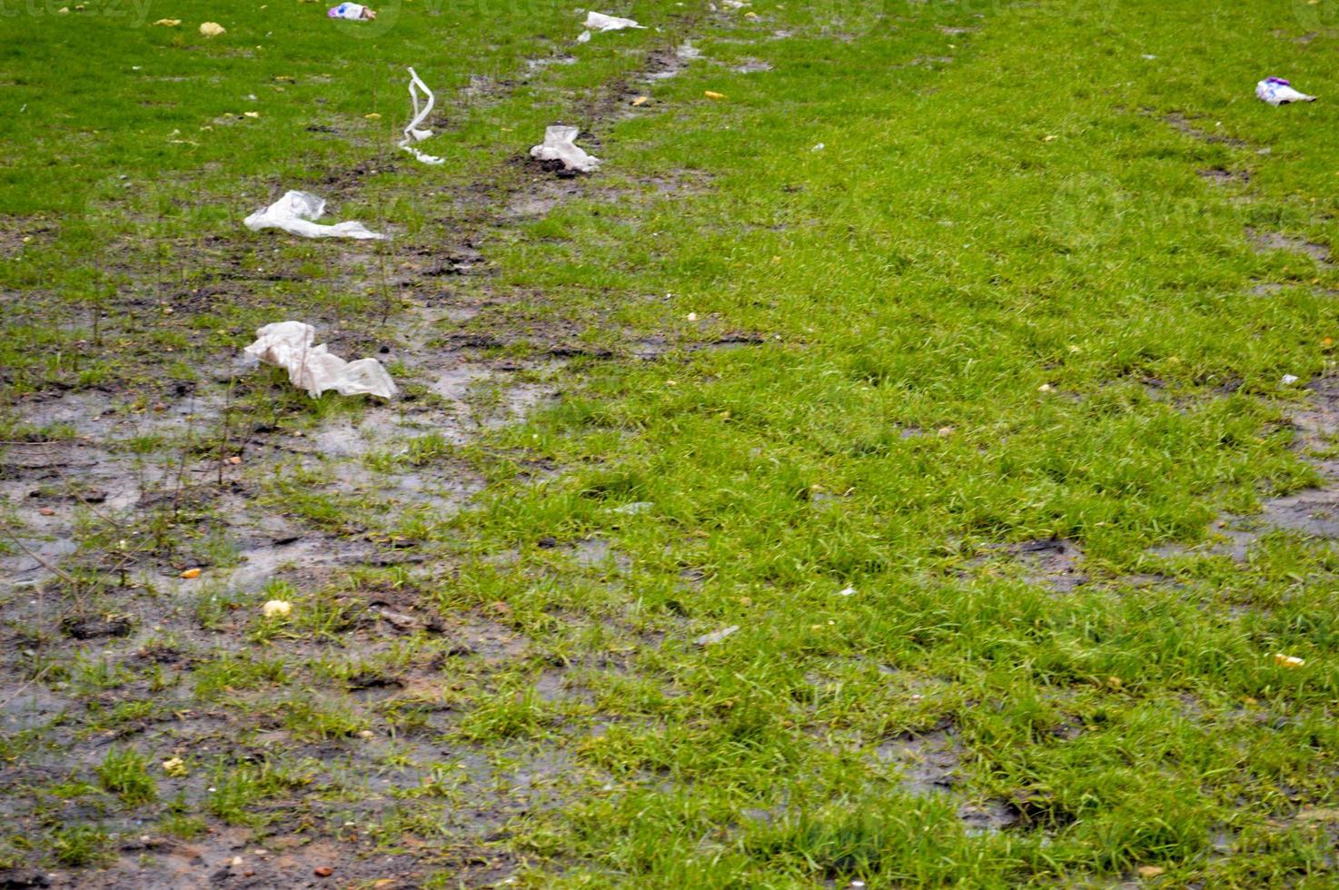 visie van groen ecologisch schoon groen gras bezaaid met vuilnis en plastic plastic Tassen. de achtergrond. textuur. concept milieu verontreiniging foto