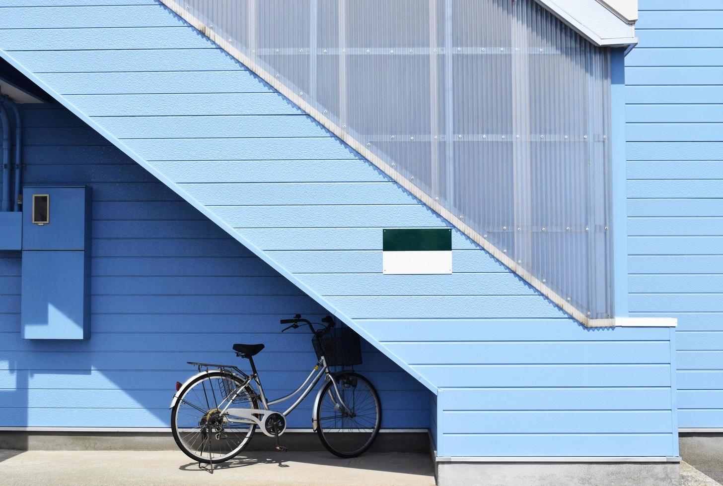 grijze fiets geparkeerd bij blauw huis foto