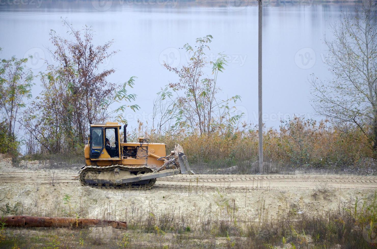 steengroeve aggregaat met zwaar plicht machines. rups- lader graafmachine met backhoe het rijden naar bouw plaats steengroeve foto