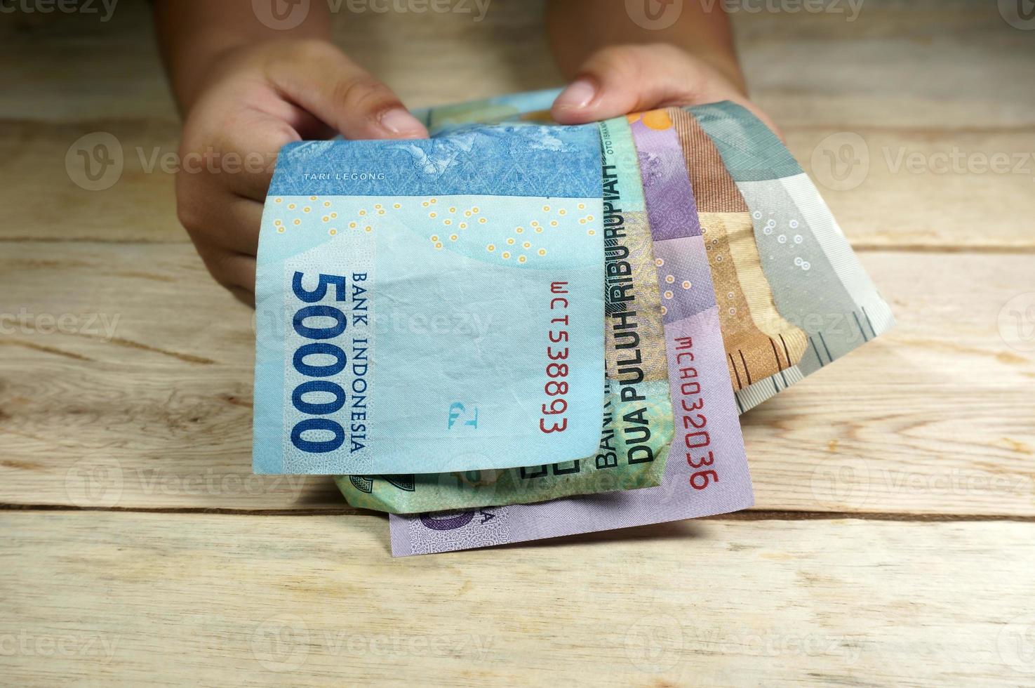 hand- van jong kind Holding Indonesisch geld. roepia, idr geld. foto