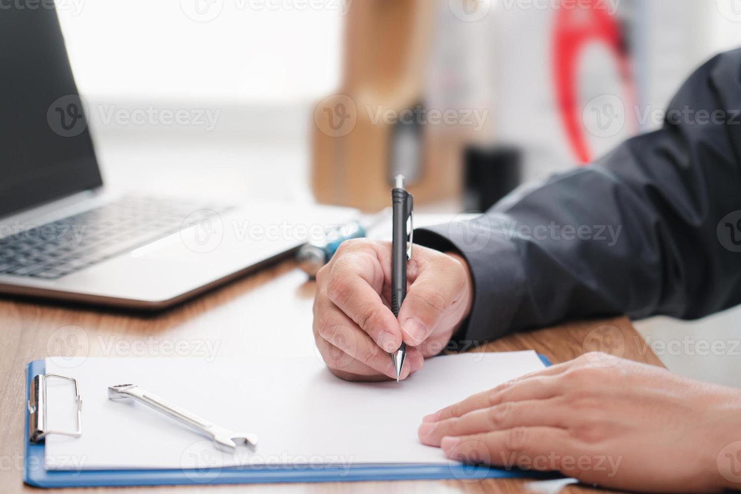 technicus schrijven Aan de wit papier klem bord het dossier en controleren de auto's kilometerstand controleren fiets naar verandering de olie , onderhoud concept foto