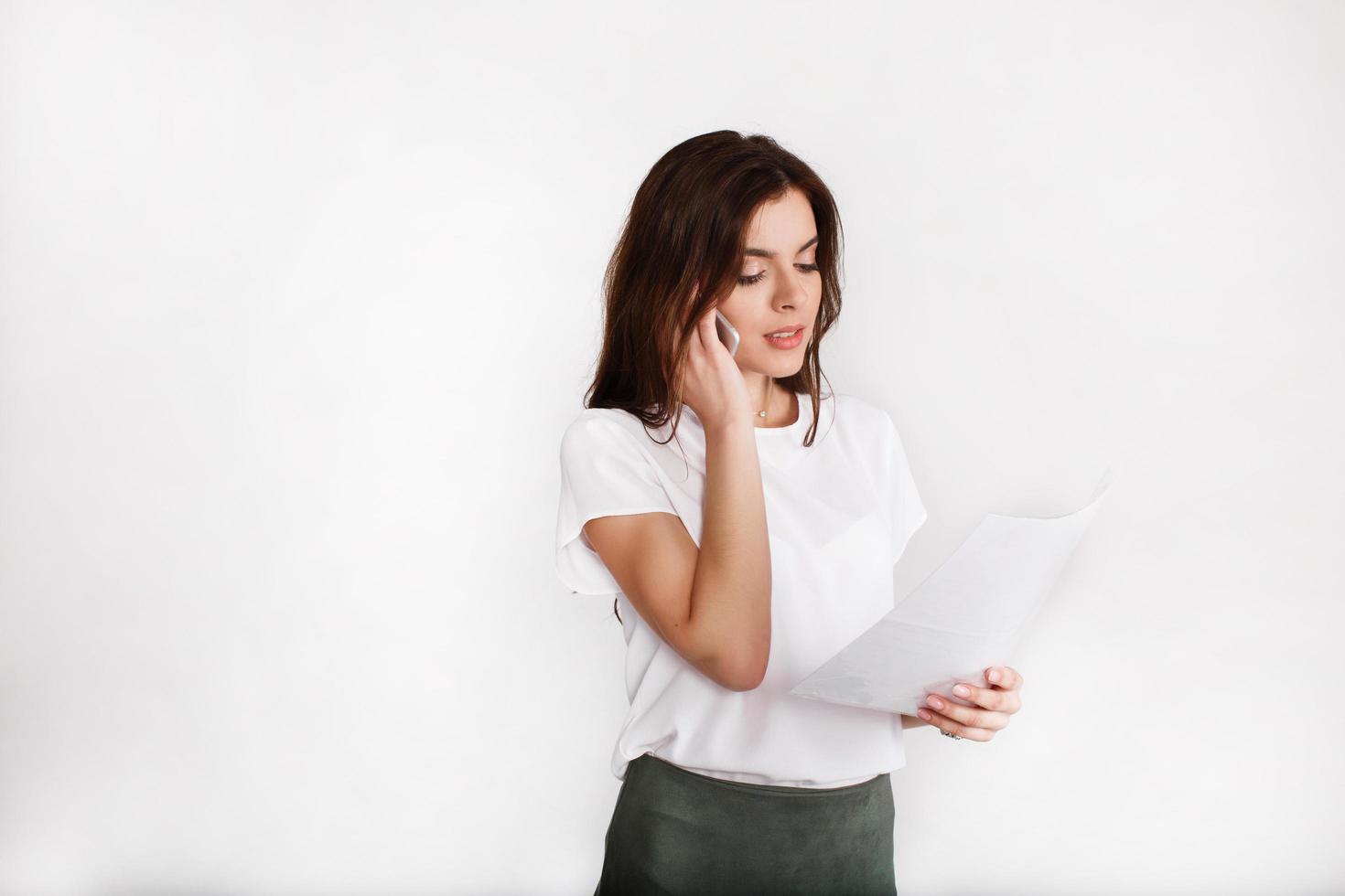 vrouw gekleed in office-stijl gesprekken aan de telefoon over papierwerk foto