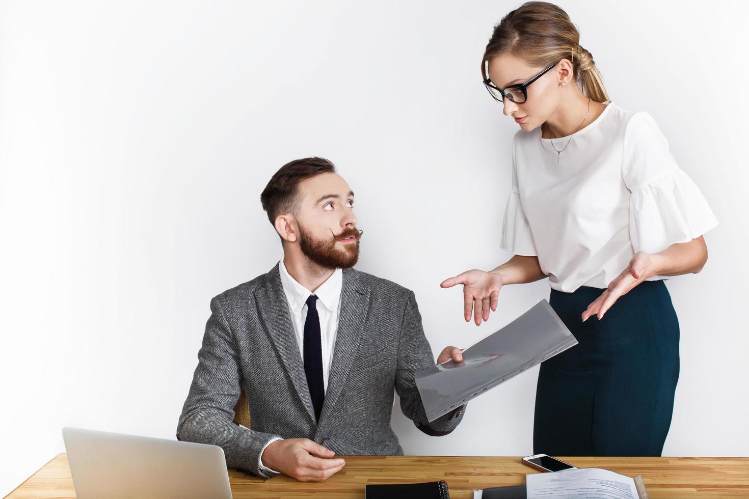 mannelijke en vrouwelijke ondernemers praten over het bureau op een witte achtergrond foto