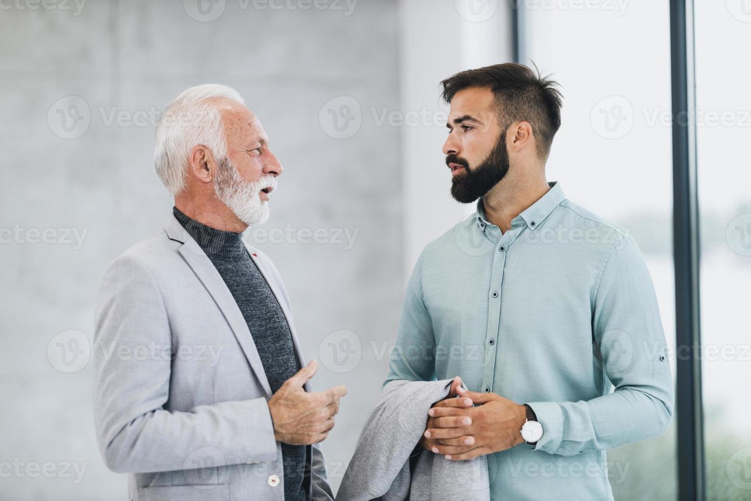 een twee zakenlieden pratend terwijl wandelen in de kantoor foto