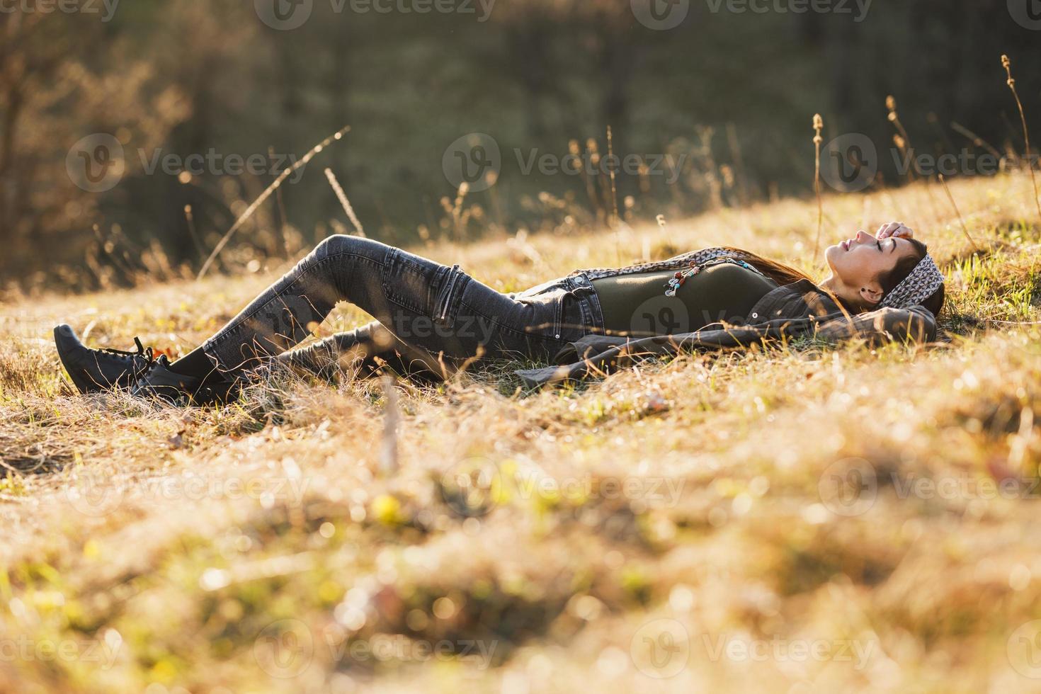 vrouw aan het liegen naar beneden Aan de weide en genieten van zon foto