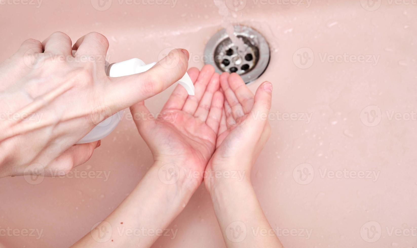 het wassen handen met zeep in badkamer foto