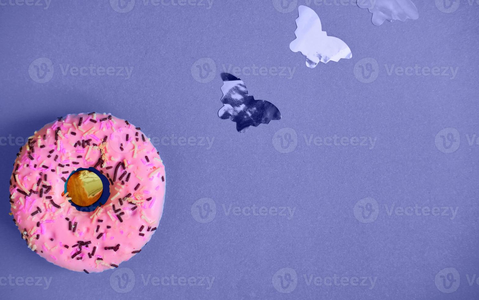 roze donut Aan een lila achtergrond met klein vlinders. kleur van de jaar heel peri foto