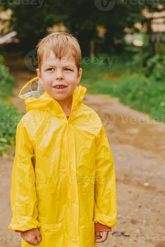 drinken kleinhandel Oh portret van een jongen in een geel regenjas Aan de straat. een eenzaam kind  verloren Aan de straat. kinderen zonder overzicht. helder kleren voor  kinderen voor een wandelen 14239327 Stockfoto