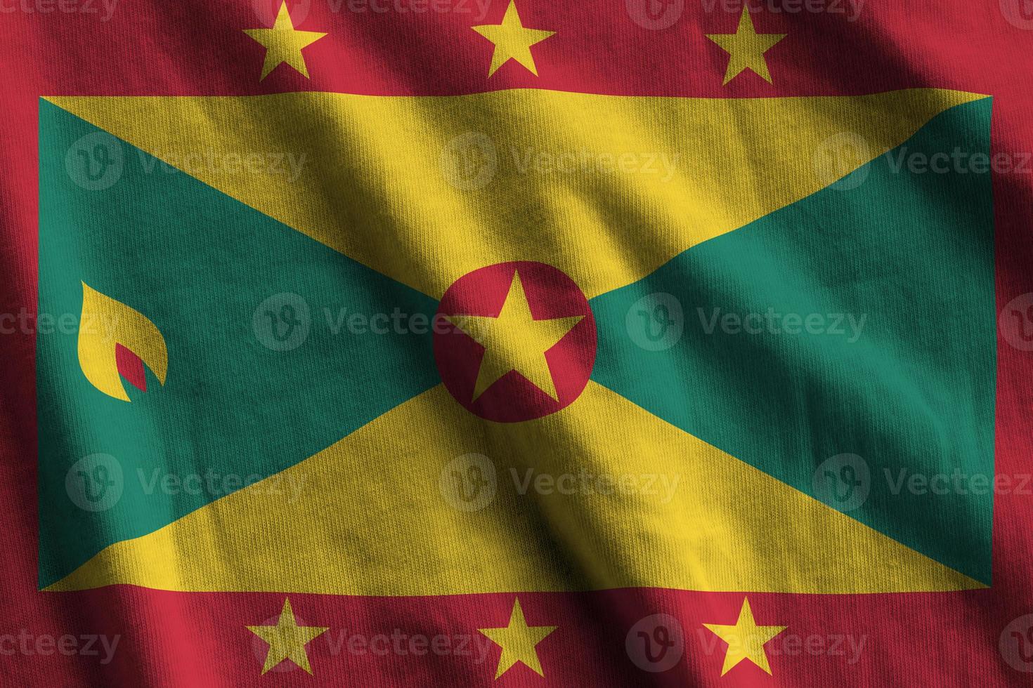 Grenada vlag met groot vouwen golvend dichtbij omhoog onder de studio licht binnenshuis. de officieel symbolen en kleuren in banier foto