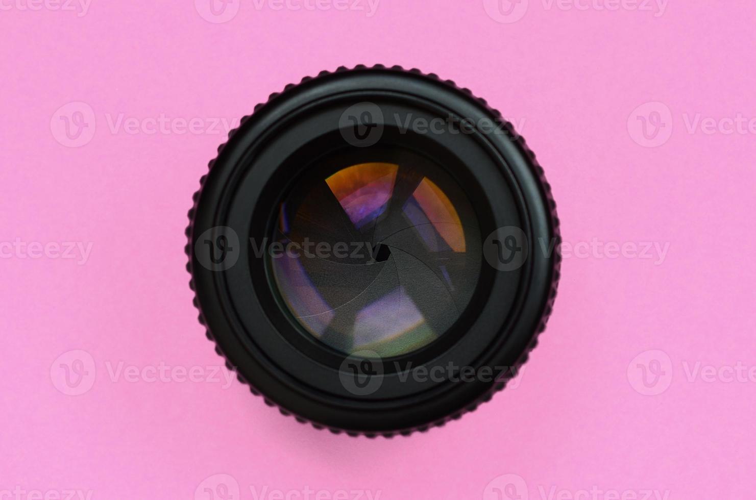 camera lens met een Gesloten opening liggen Aan structuur achtergrond van mode pastel roze kleur papier in minimaal concept foto