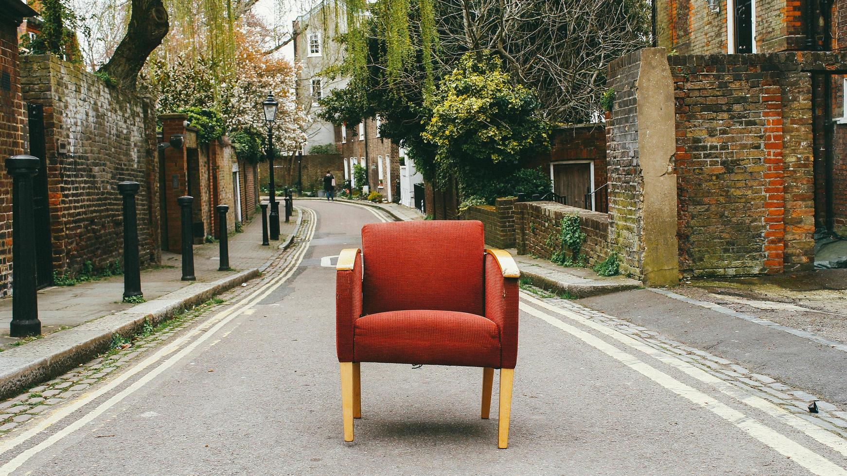 Londen, Verenigd Koninkrijk, 2020 - versleten rode stoel in straat foto