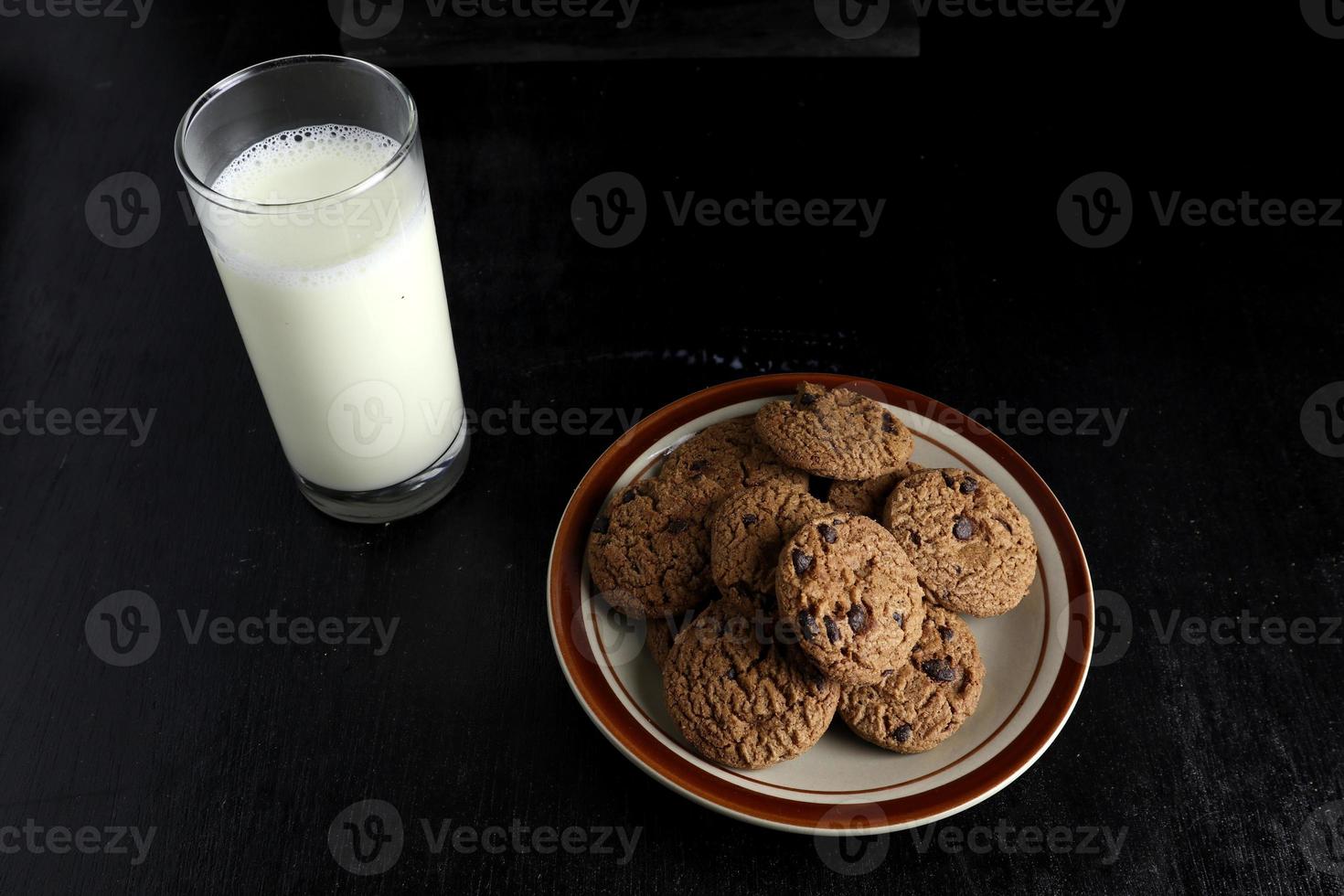 koekjes en melk Aan zwart achtergrond. ruimte voor tekst foto