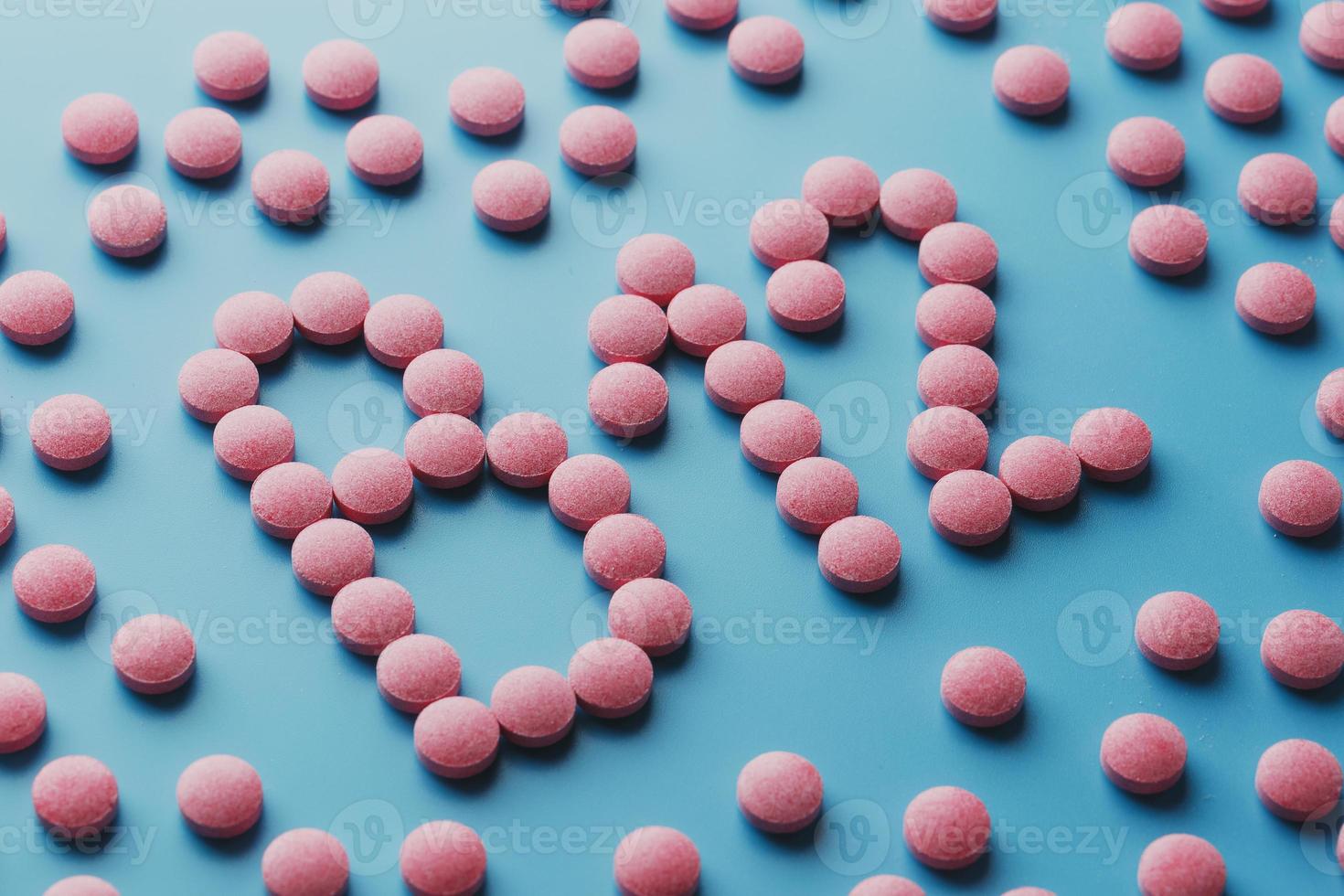 roze tablets in de het formulier van b12 detailopname Aan een blauw achtergrond, laag contrast foto