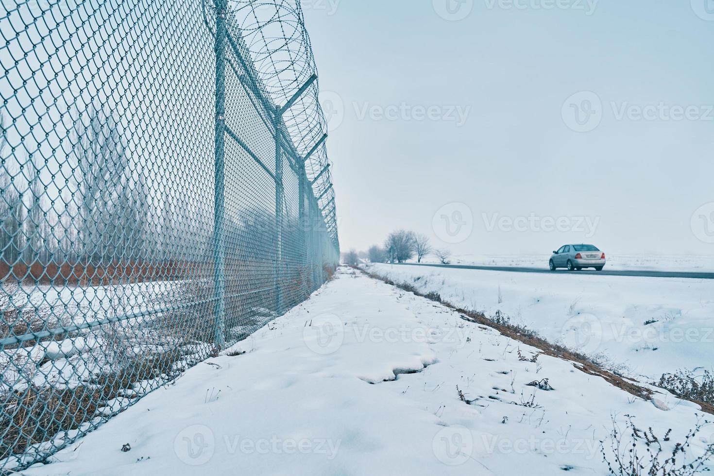 hek met met weerhaken draad Aan de grens van de voorwerp. foto