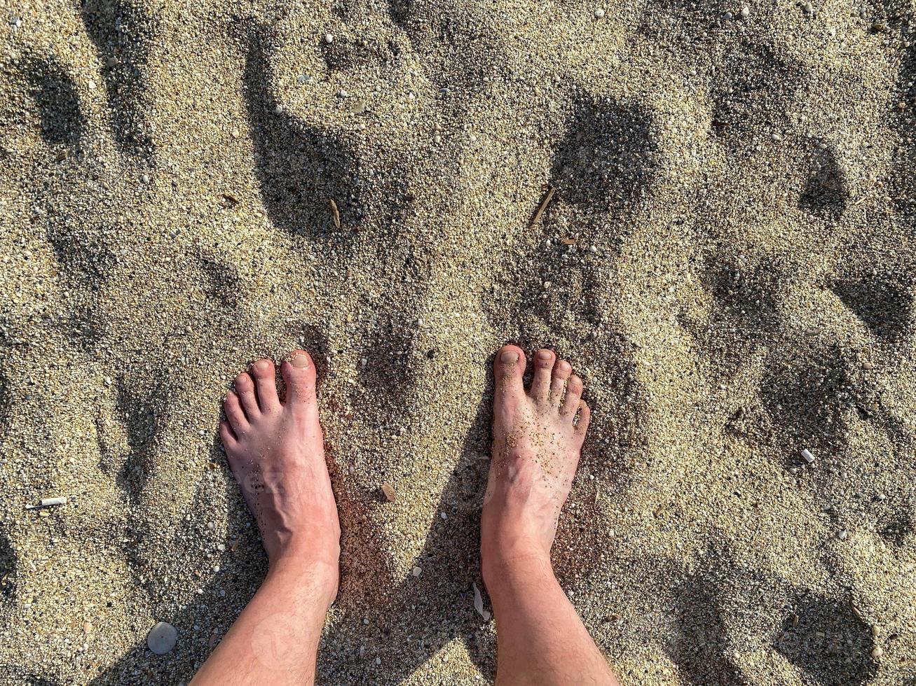 poten, voeten tegen de achtergrond van kruimelig geel gouden zand Aan vakantie Aan de strand in een warm tropisch oostelijk paradijs land zuidelijk toevlucht foto