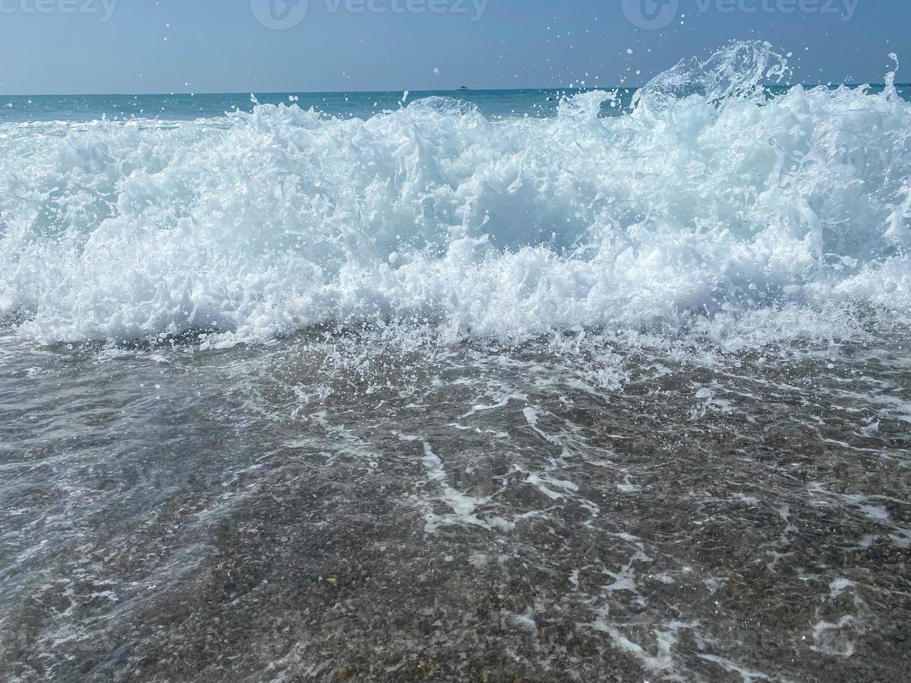 mooi zee met golven spatten warm sprankelend Doorzichtig blauw water in een warm tropisch oosters land zuidelijk toevlucht. achtergrond, structuur foto