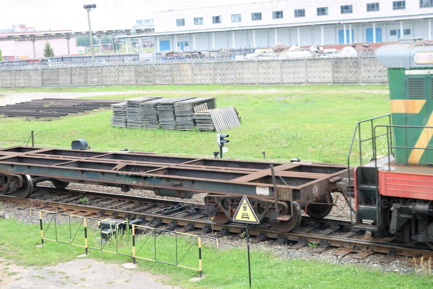 groen metalen ijzer op wielen vracht trein, locomotief voor de vervoer van goederen Aan rails Bij de spoorweg station foto