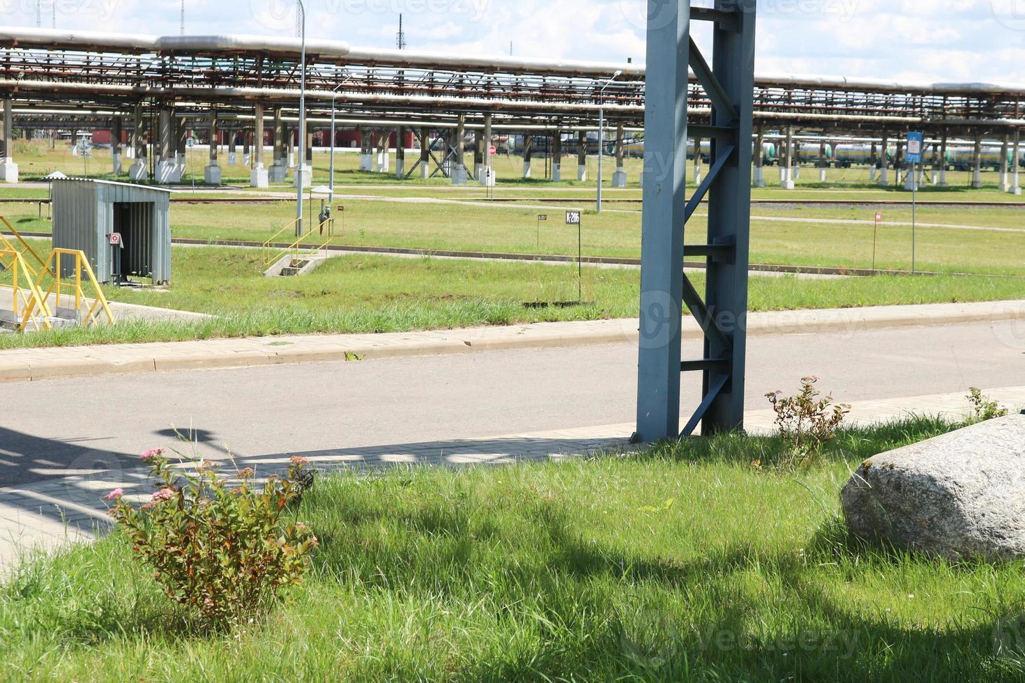 een groot ijzer metaal leidingen schraag met pijpen en elektrisch draden en uitrusting Bij de petrochemisch raffinaderij industrieel raffinaderij foto